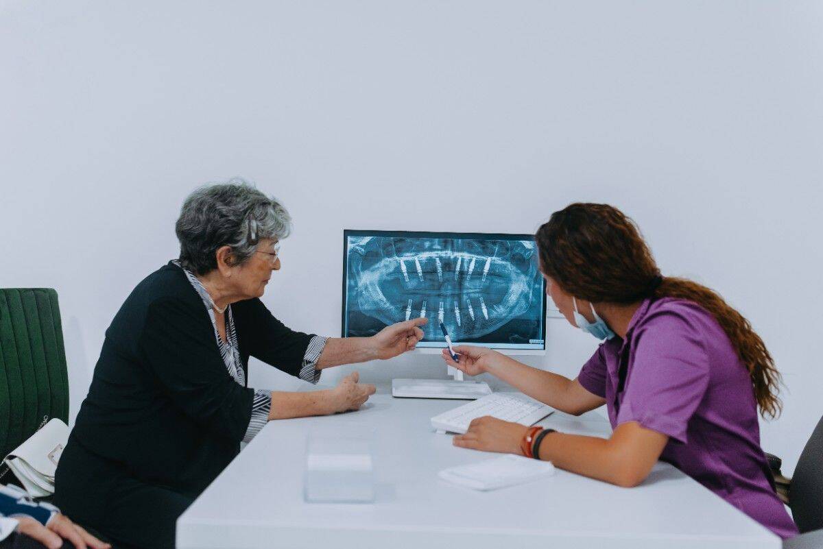 Dentist reviewing dental X-ray with senior patient during consultation