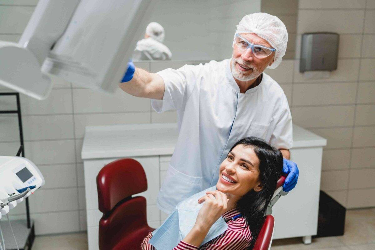 Smiling woman receiving an orthodontic consultation while seated in a dental treatment chair