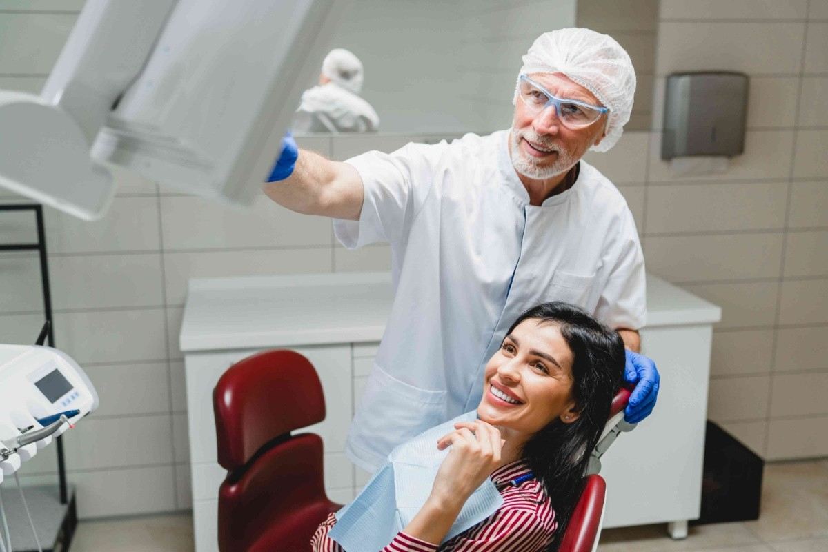Smiling woman receiving an orthodontic consultation while seated in a dental treatment chair